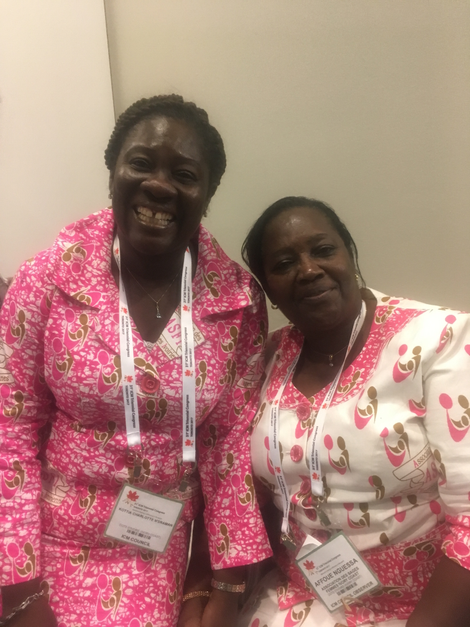 Midwives from the Ivory Coast at the opening ceremony, both wearing dresses made with custom textiles bearing their midwife association’s name. Photo by Kathryn Jezer-Morton.